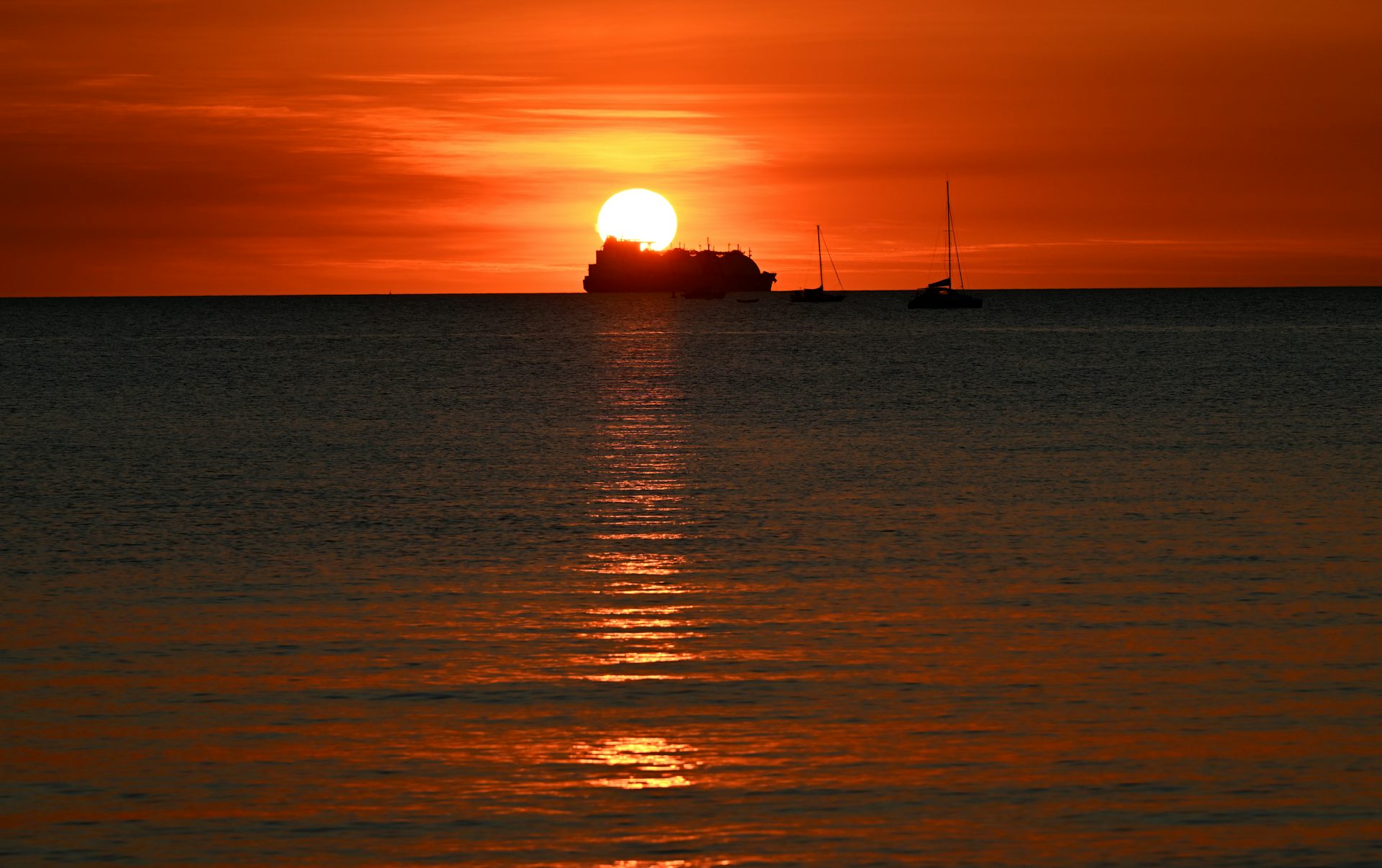 container ship setting sail at sunset