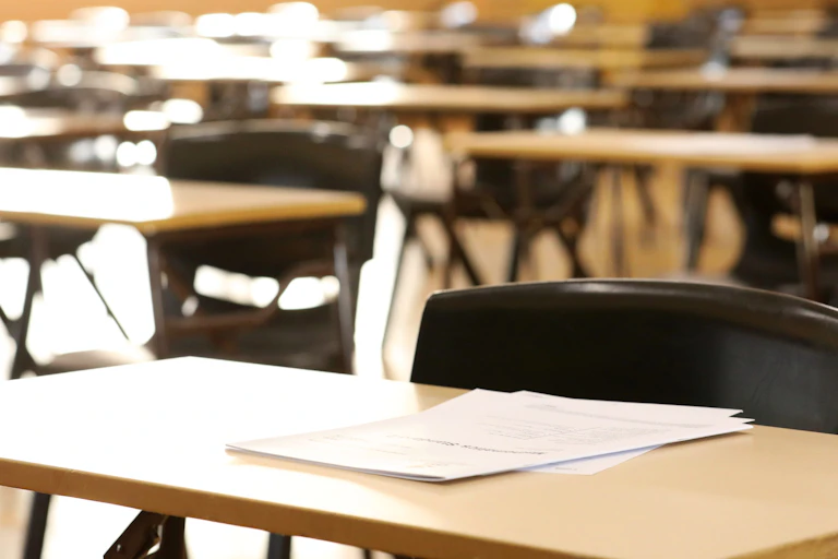 Empty desks in an exam hall.