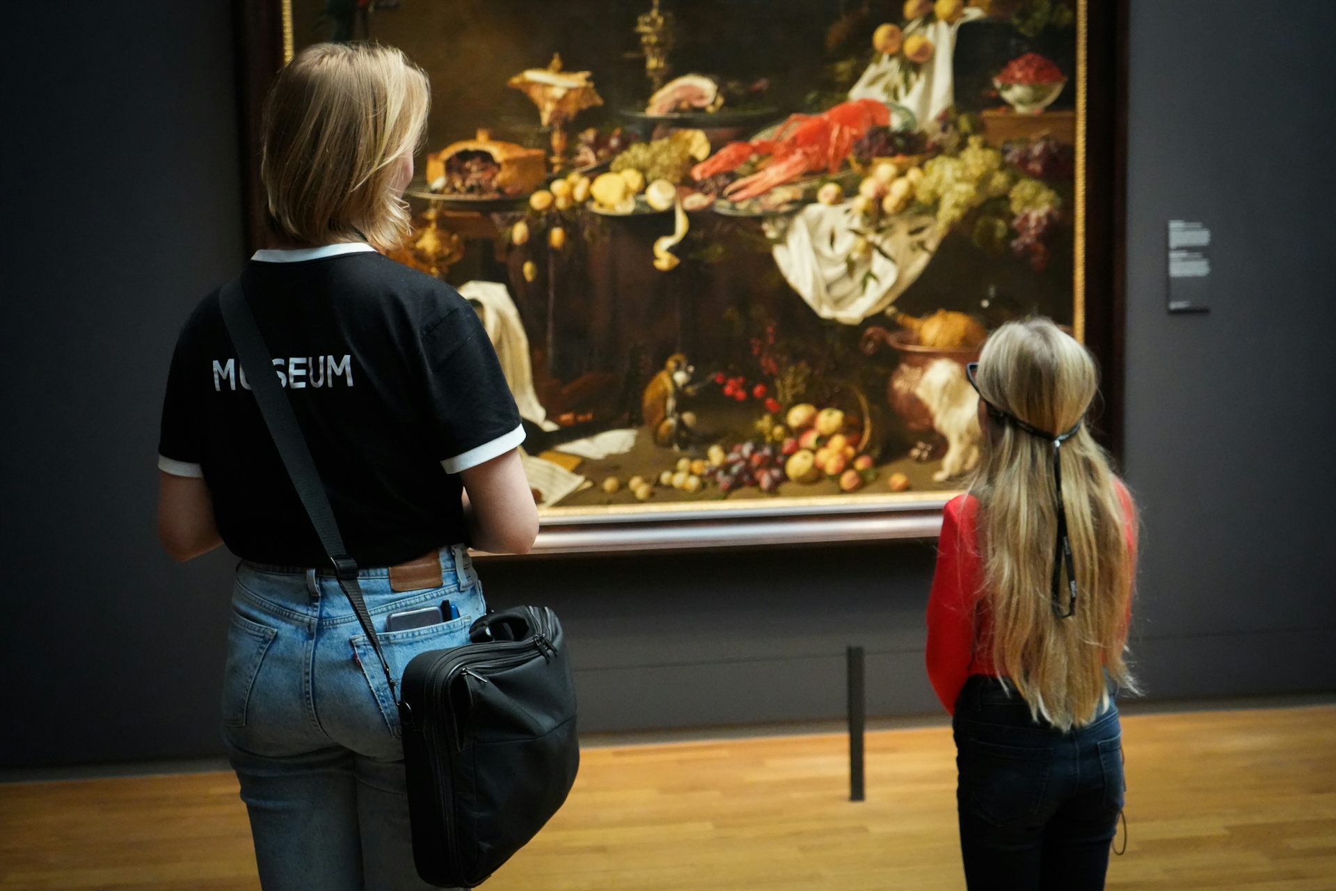 Adult and child looking at still life painting, child wearing glasses