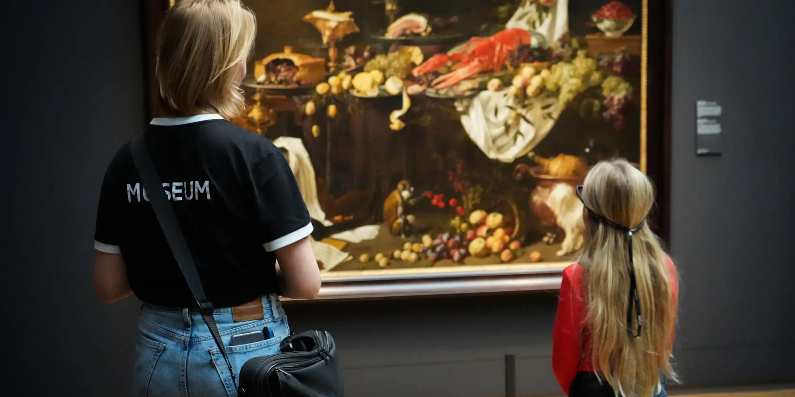 Adult and child looking at still life painting, child wearing glasses