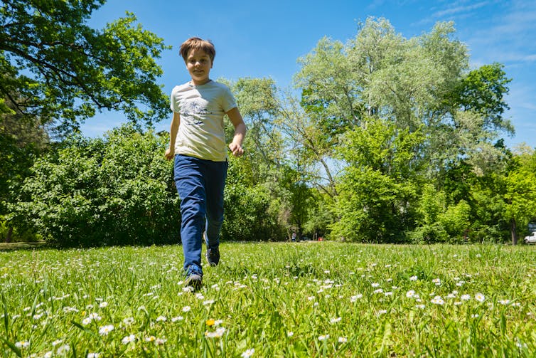 Boy walks across grass