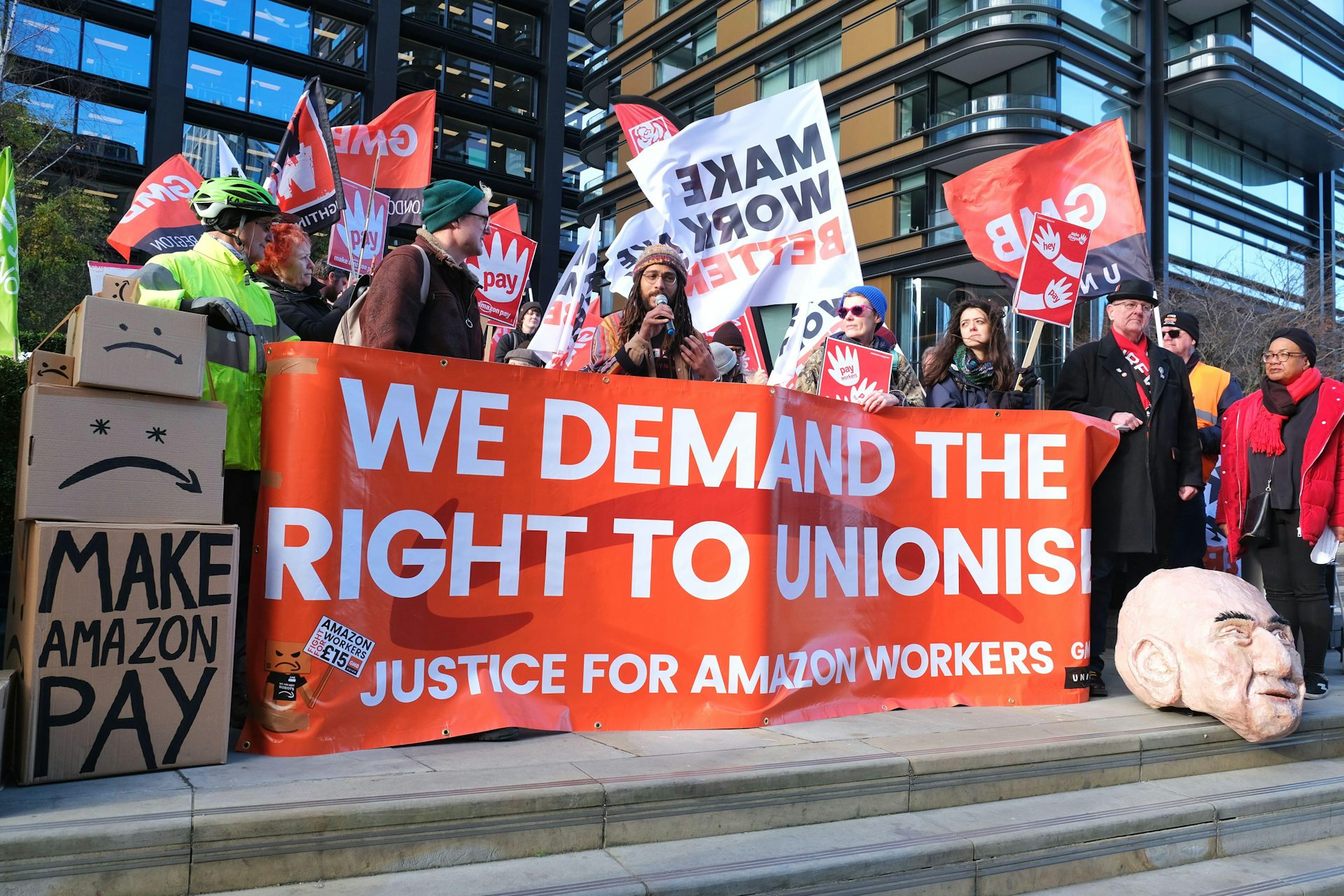 Amazon workers hold up a banner saying 'We demand the right to unionise'