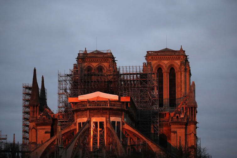 A view of Notre-Dame Cathedral illuminated by red light.