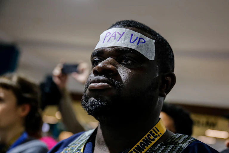 Man protesting with pay up sign on his forehead