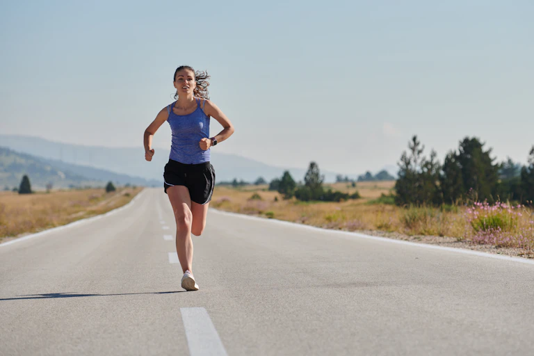 A determined woman runs along a deserted road