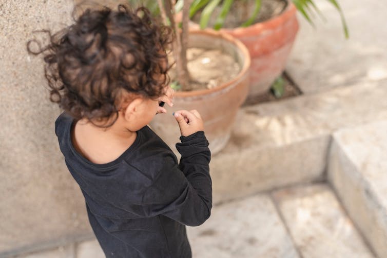 Toddler holding a small bead