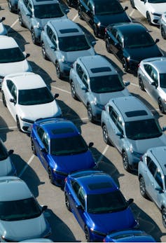 An aerial view of new cars parked at a car factory