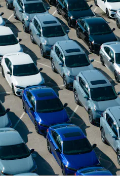 An aerial view of new cars parked at a car factory
