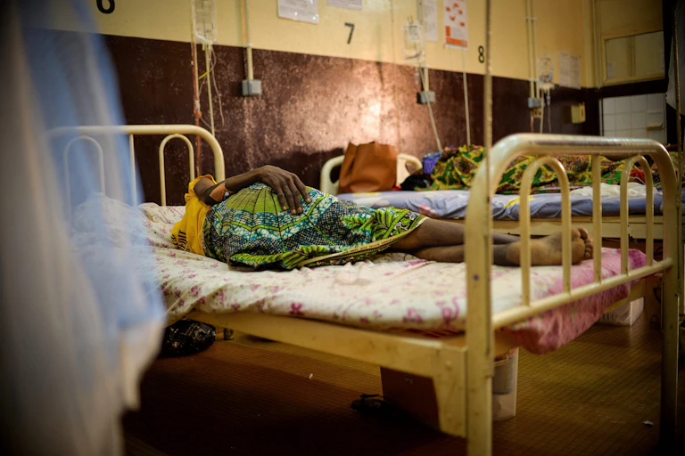 Woman lying on a bed in a hospital ward