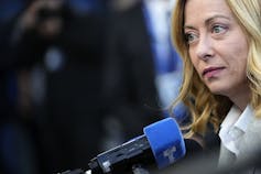 A microphone near the face of a of a woman with blond hair.