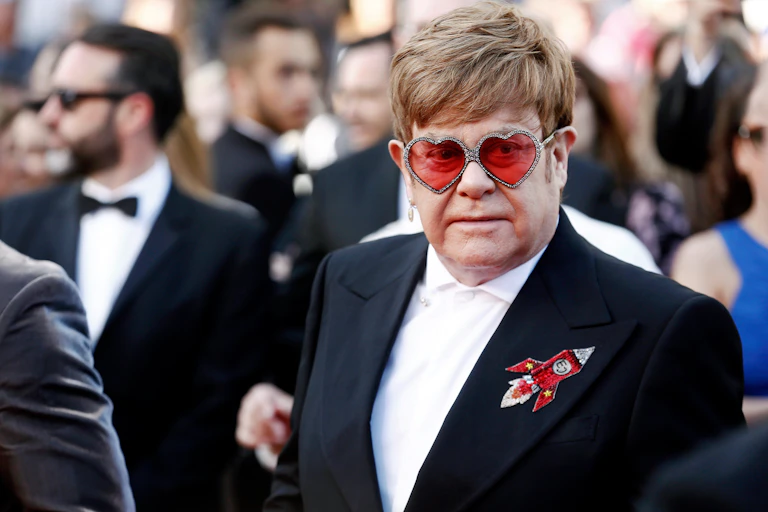 Sir Elton John wearing heart shaped glasses.