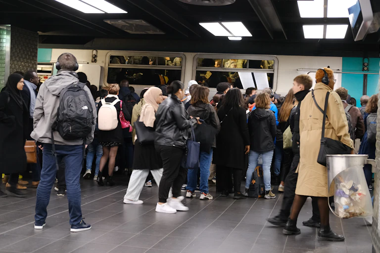 une petite foule sur un quai souterrain attend pour montrer dans un RER à deux étages qui semble bondé