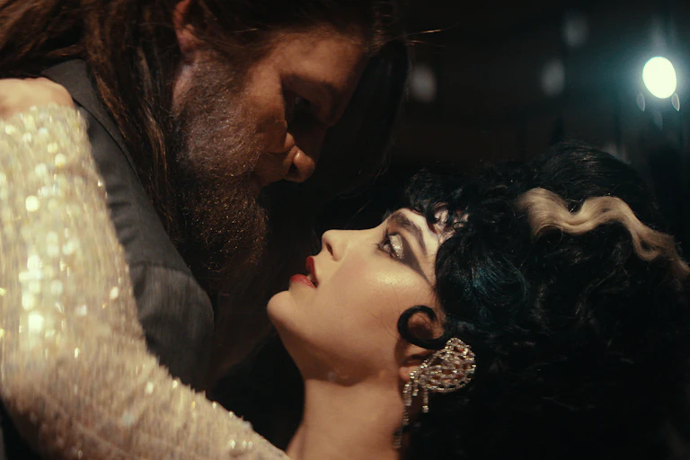 A woman dances with a monster, they look like beauty and the beast