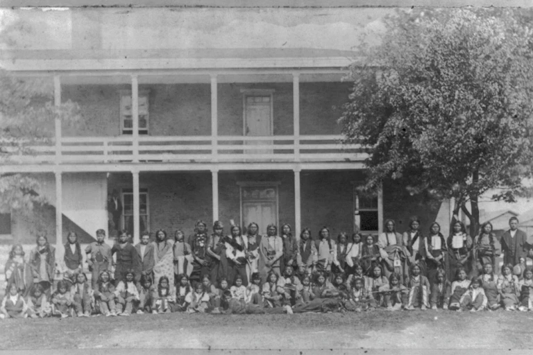 Black and white photograph of people outside a building.