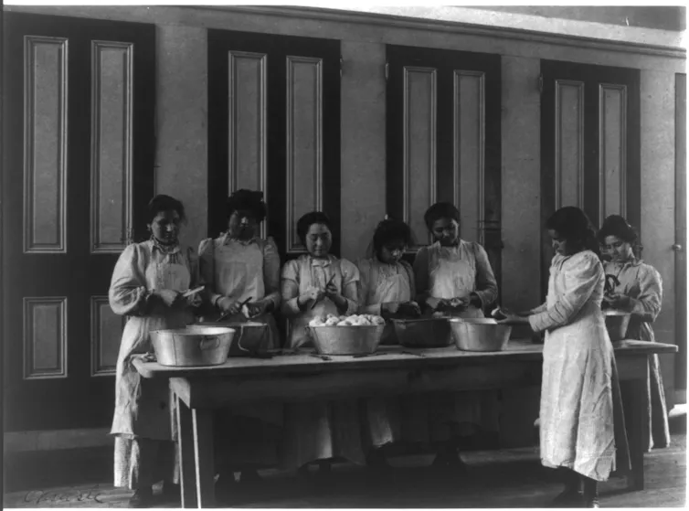 Black and white photograph of girls preparing food