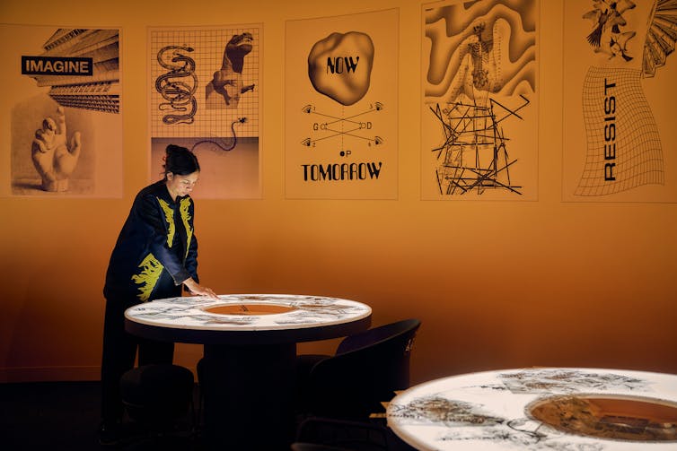A woman leans over a table.