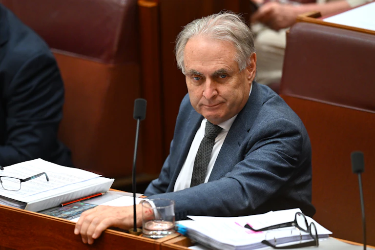 A man in a suit sits in the senate