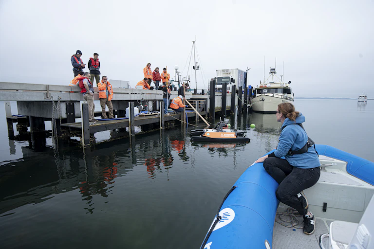 Scientists working on a recent ocean alkalinity enhancement pilot in Tasmania, with various vessels on the water