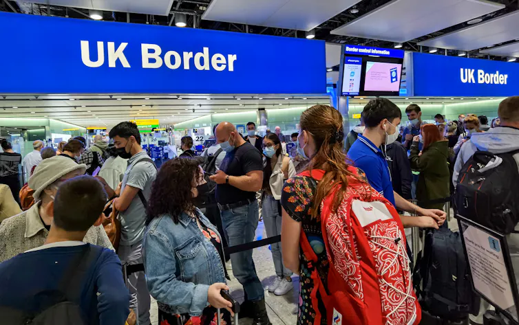 A queue of travellers at the UK border in an airport