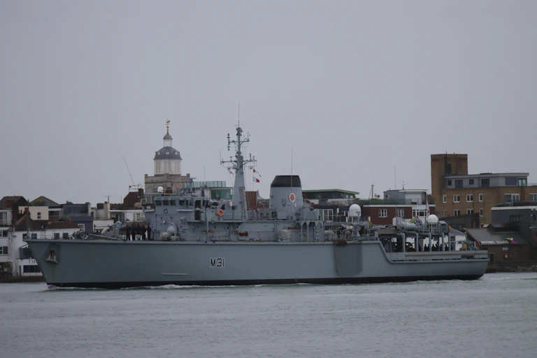 HMS Cattistock, a Royal Navy Hunt Class minesweeper sails out of Portsmouth harbour.