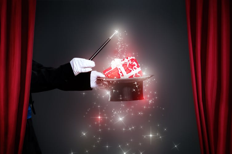 A magician with a present appearing out of his top hat