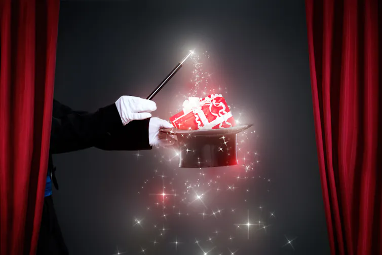 A magician with a present appearing out of his top hat