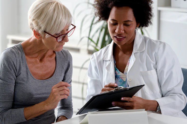 A woman with gray hair and a doctor in a white lab coat