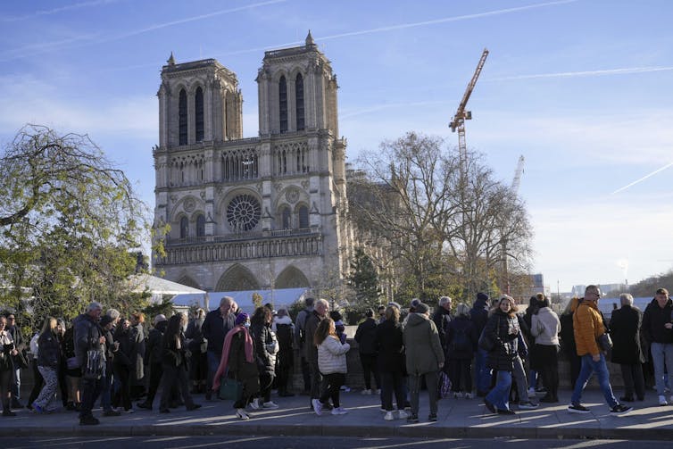 People gather in front of Notre Dame Cathedral in Paris, France.