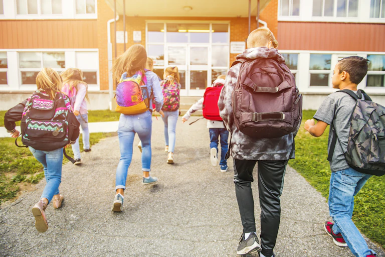 A group of kids go to the school. Back view