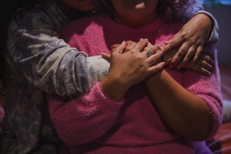 An Indigenous women puts her arms around another