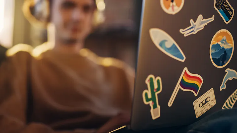A close-up of a pride flag sticker on a laptop