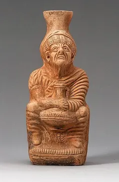 A terracotta jug depicting an old woman.