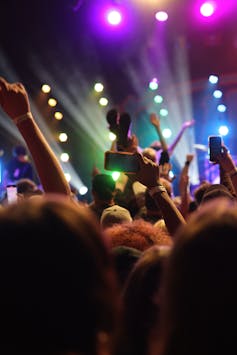 Crowd of concert goers enjoying a live show with their hands up