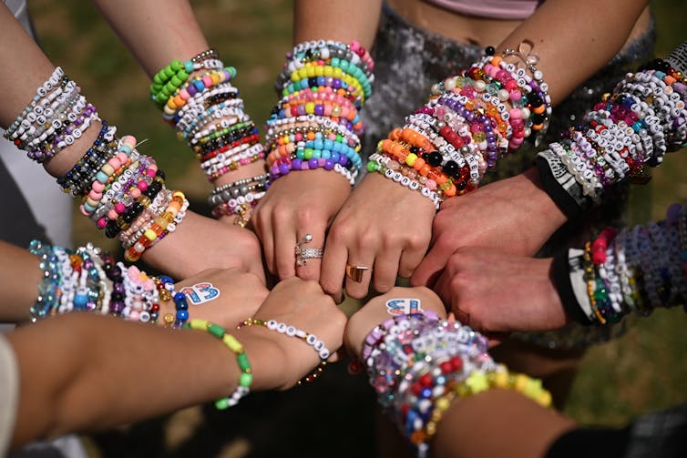 A gaggle of hands covered in friendship bracelets.