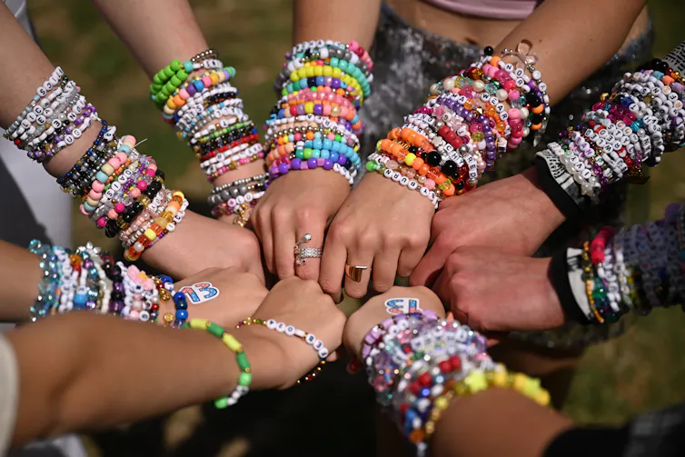 A gaggle of hands covered in friendship bracelets.