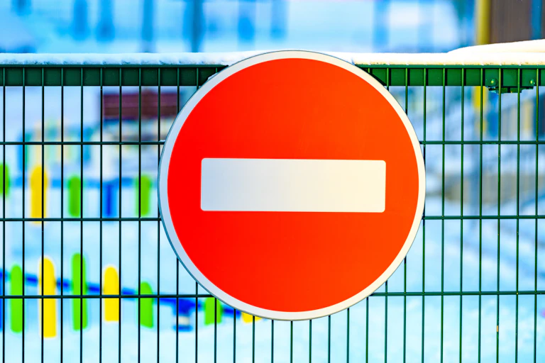 A no entry road sign on a fence.