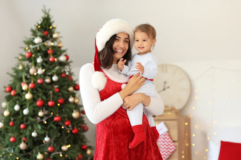 A mum dressed as Santa with her baby