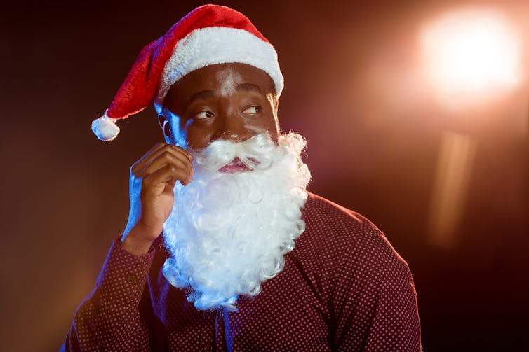 A main disguised as Santa twiddling his beard.