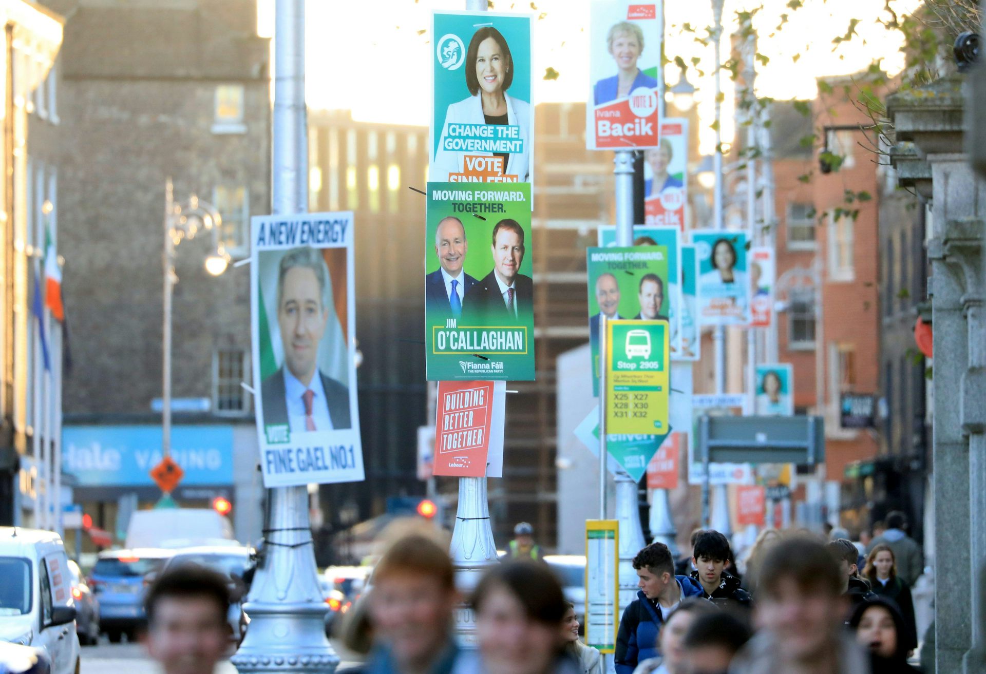 Posters for various candidates cover lampposts on a street in Dublin city centre