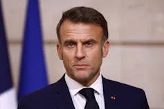 A dark-haired man in a suit and tie.