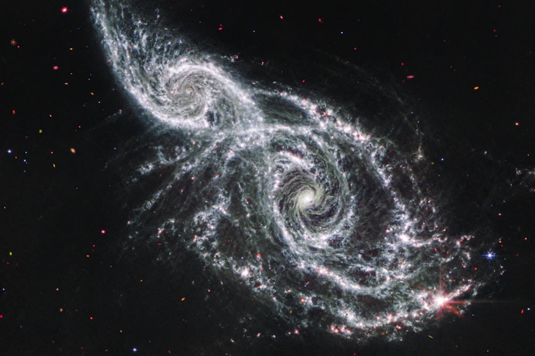 Imagem de duas galáxias, IC 2163 e NGC 2207.