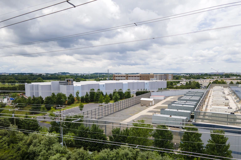 Large square buildings with numerous power lines in the foreground