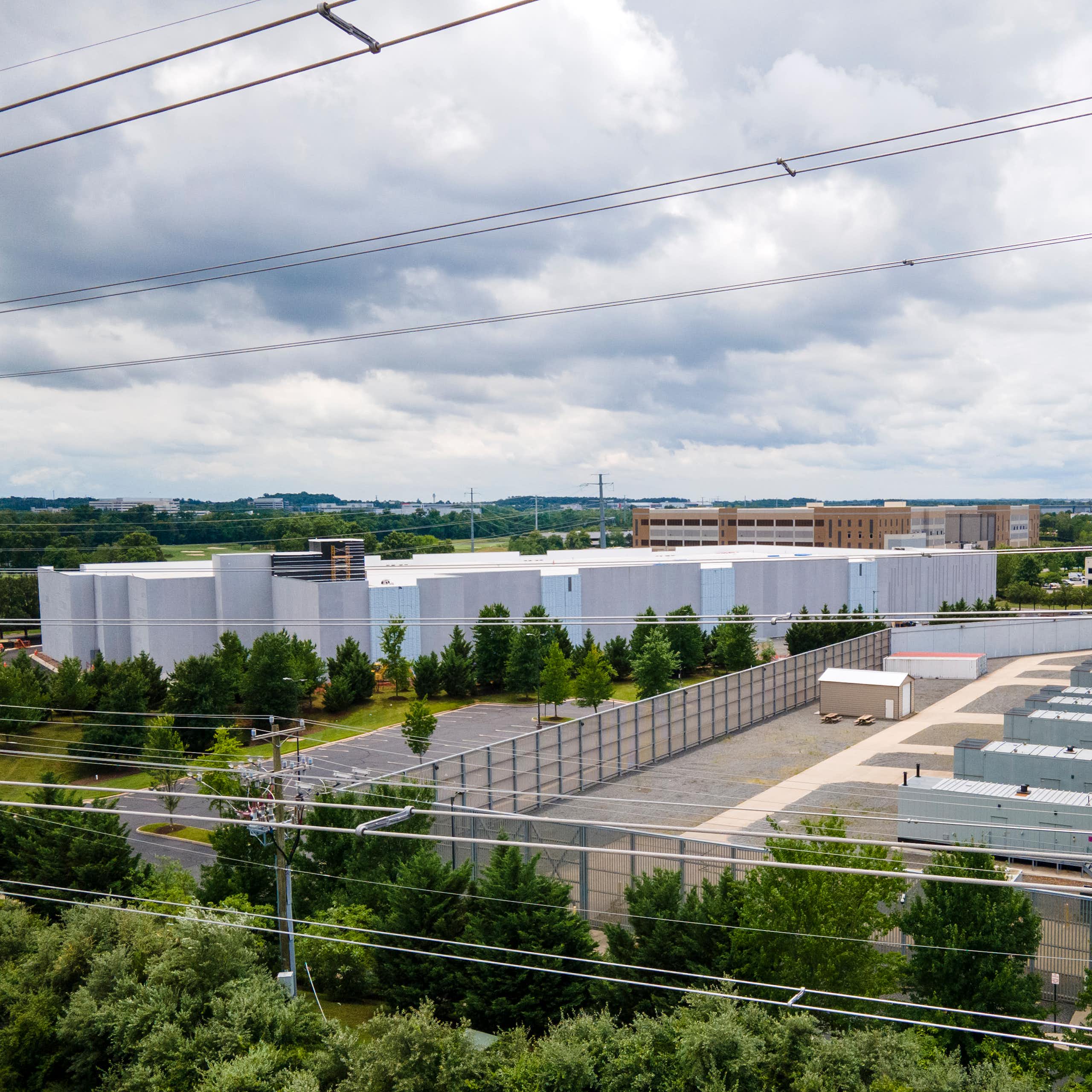 Large square buildings with numerous power lines in the foreground