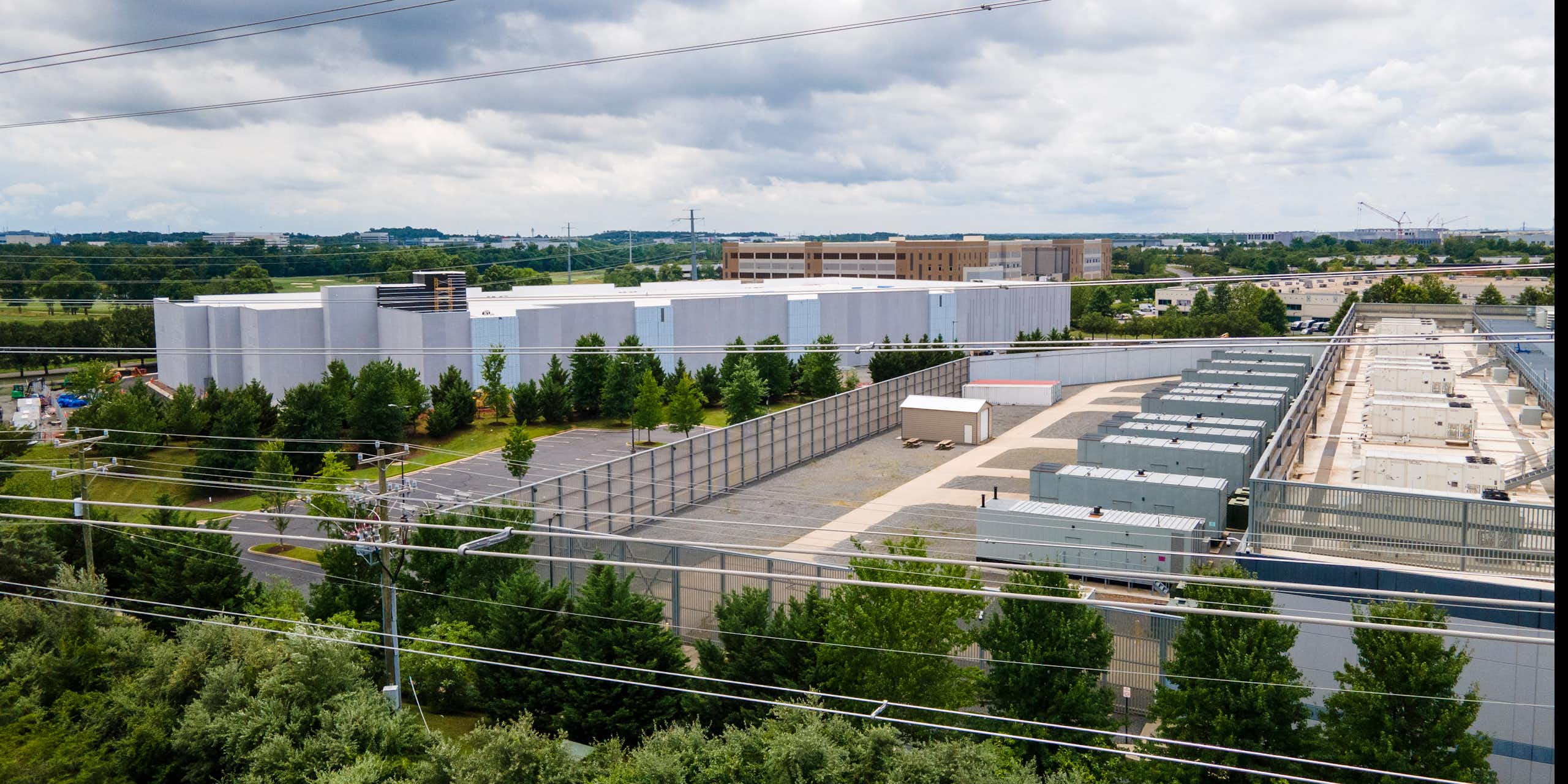Large square buildings with numerous power lines in the foreground