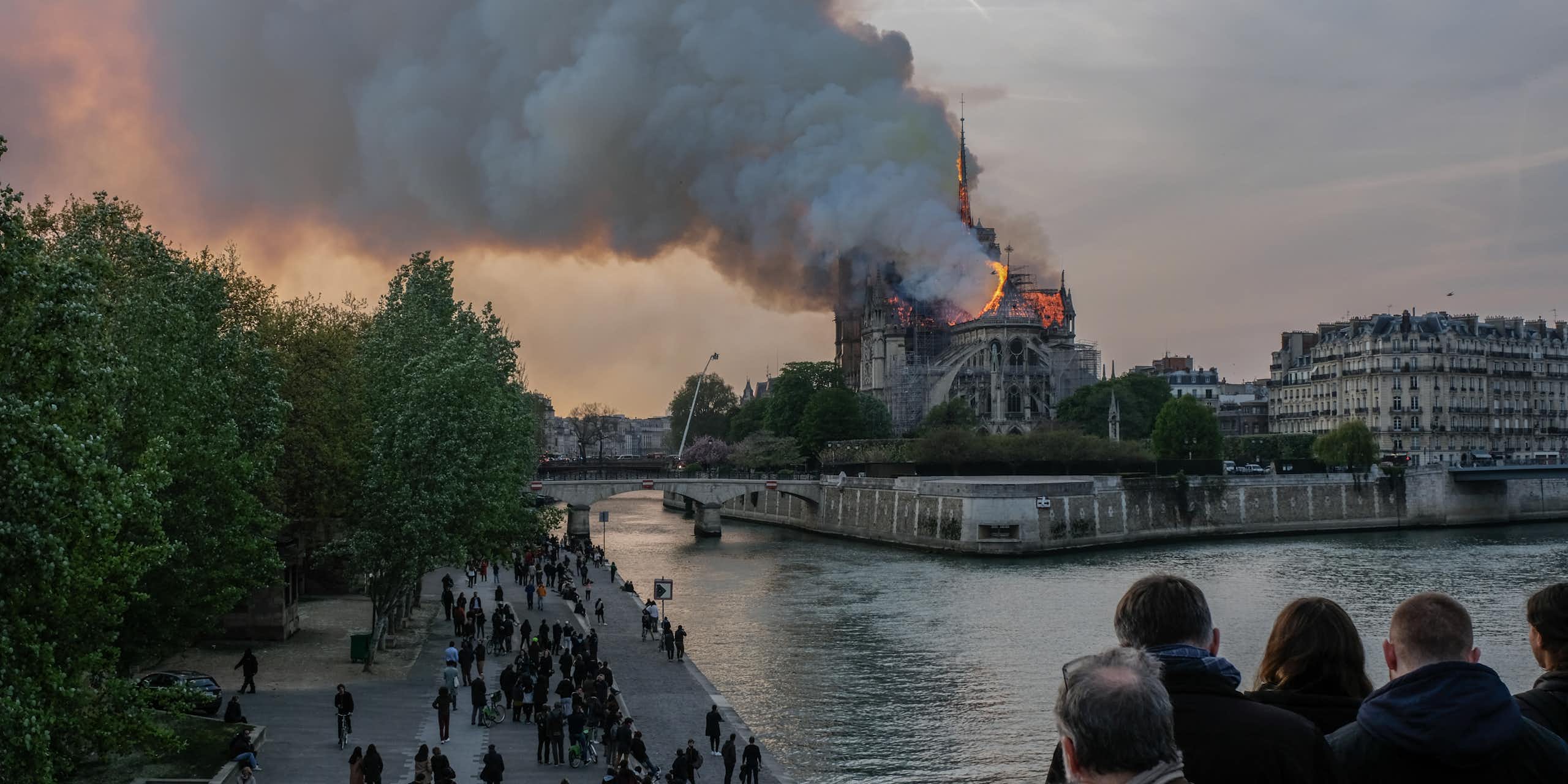 People watch Notre Dame Cathedral burn.