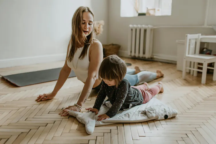 Une mère fait un étirement avec son enfant