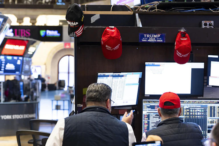 A trader with Trump merchandise hanging around his workspace on the floor of the New York Stock Exchange in New York, New York, USA, 06 November 2024.