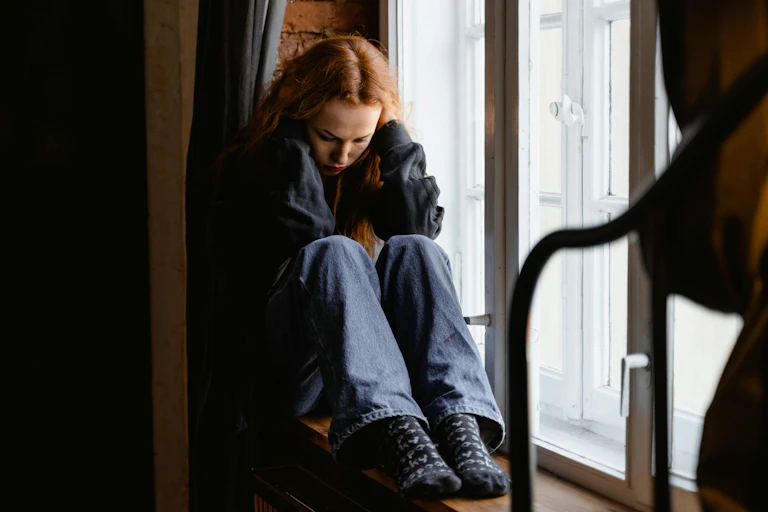 Woman crouches, in pain