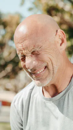 Man grimaces in pain