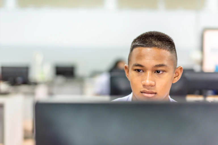 A high school student works in a computer lab.